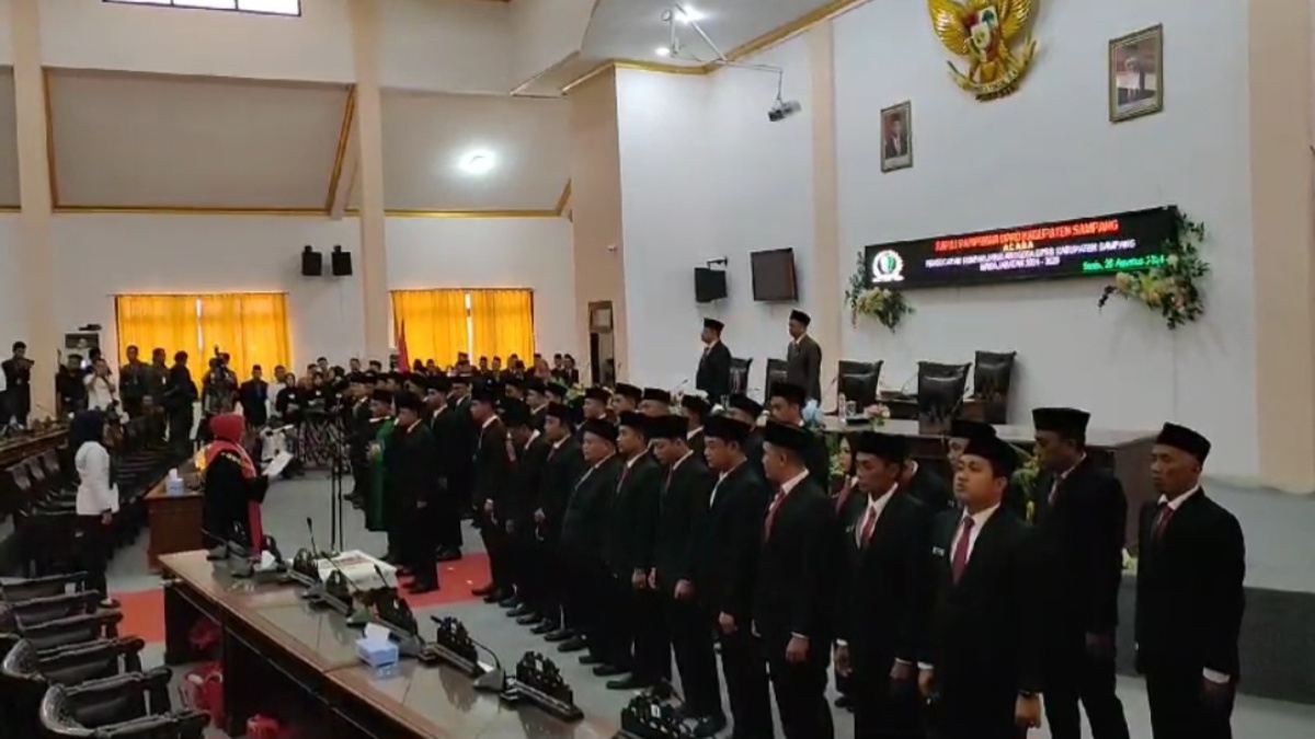 45 anggota DPRD Sampang berdiri berjejer menhadap ke tamu undangan ketika mengikuti proses pelantikan dan pengambilan sumpah jabatan di Gedung Graha Paripurna DPRD Sampang, pada Senin (26/8/2024).