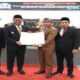 Pimpinan DPRD Sampang bersama Wakil Bupati Sampang H. Ahmad Mahfudz didampingi Sekdakab menunjukkan hasil persetujuan bersama dua raperda di dalam gedung graha DPRD Sampang.